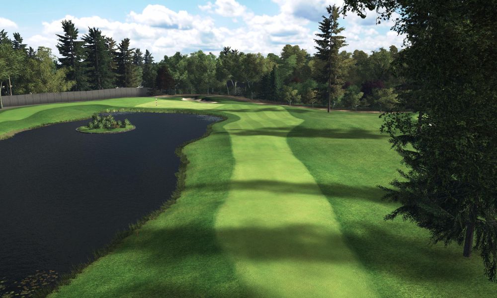 Golf course with a green and water feature surrounded by trees