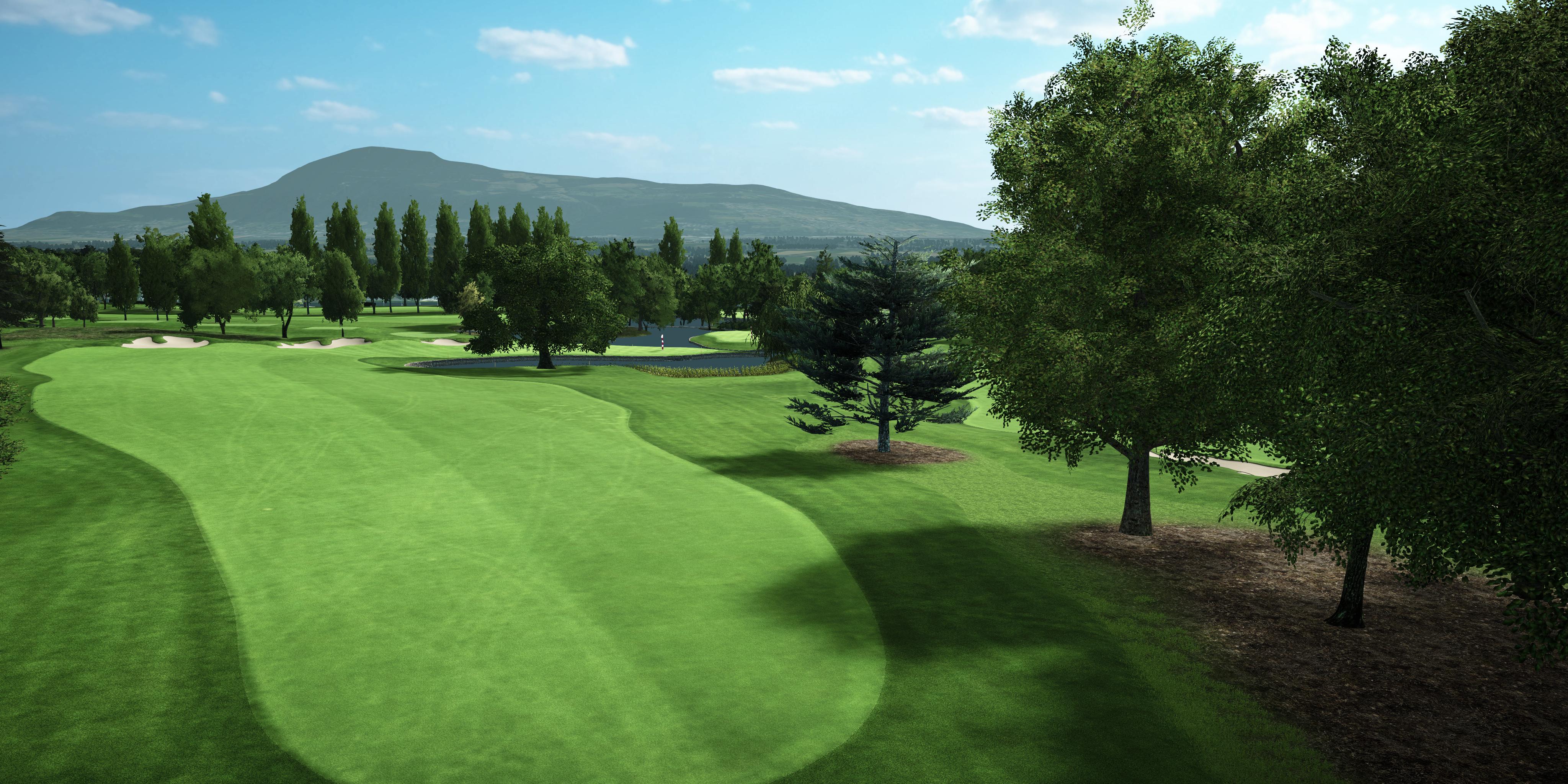 Golf course with green grass, trees, and mountains in the background
