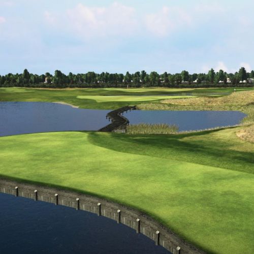 Golf course with green grass, water body, and trees under a blue sky.