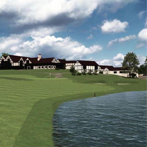 Golf course with clubhouse and lake under a blue sky with clouds