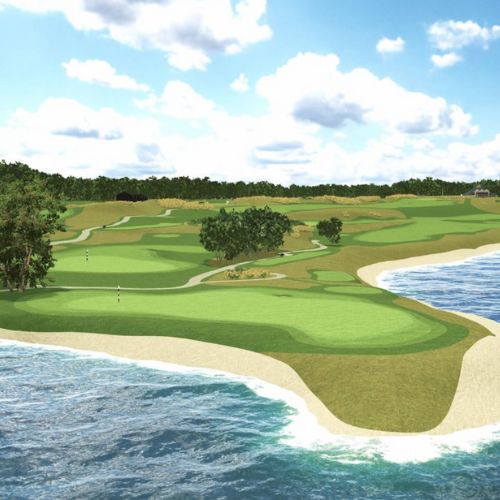 Golf course with ocean view and green grass under a blue sky with clouds.