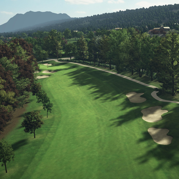 Aerial view of a lush green fairway at Evian Resort Golf Club, featuring sand bunkers, dense trees, and alpine mountain scenery.