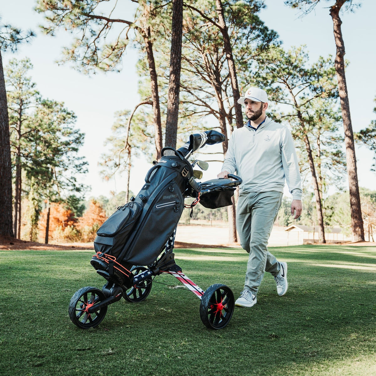 Golfer walking a fairway with a Motocaddy Nitron LTD electric golf trolley, showcasing the compact, lightweight design of this premium golf cart on the course.